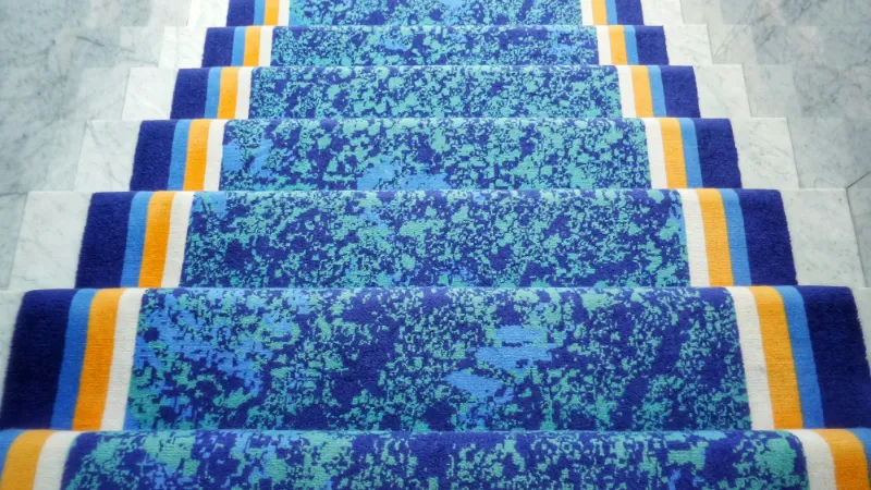 Blue mottled carpet covering a long flight of stairs