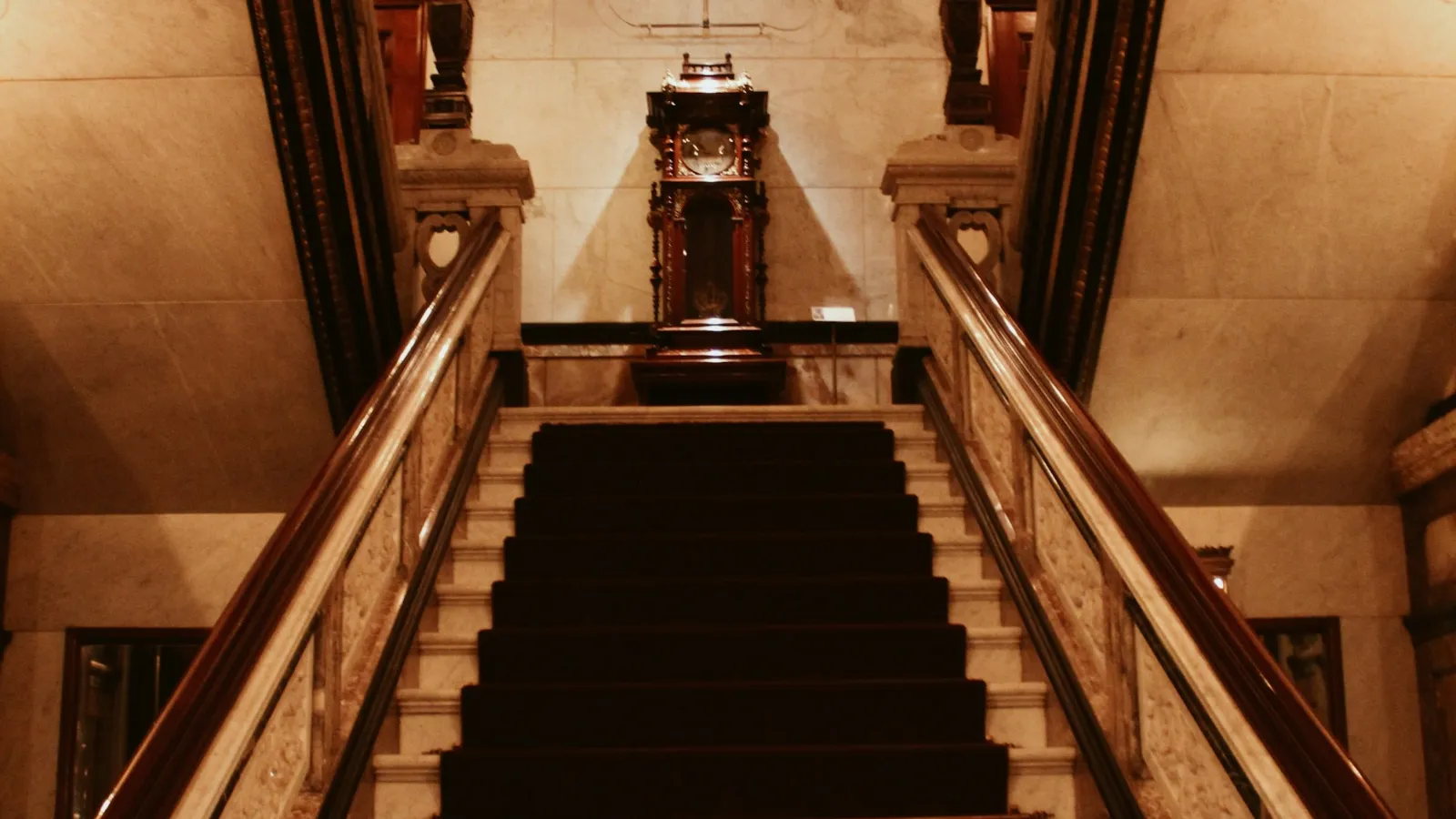 Dark runner on a staircase between timber balustrades