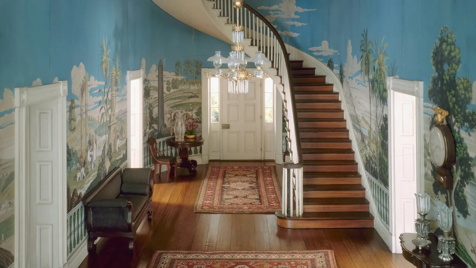 Entrance hall with a carpeted staircase and patterned rugs