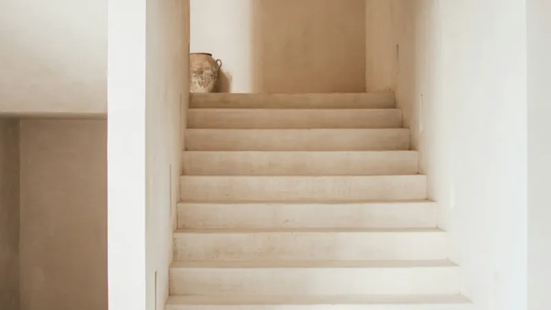 Pale stairs in a bright, narrow stairwell