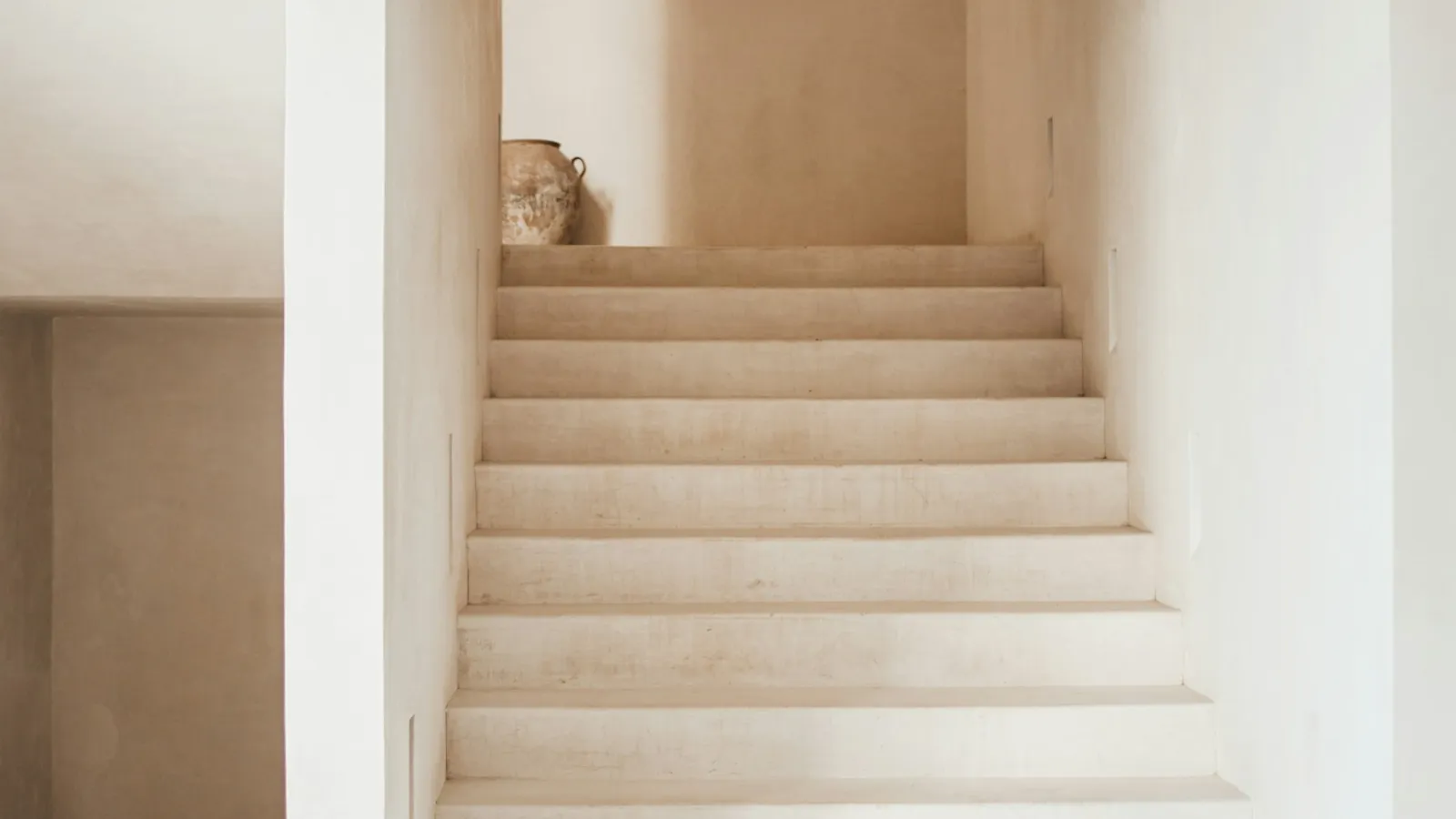Pale stairs in a bright, narrow stairwell