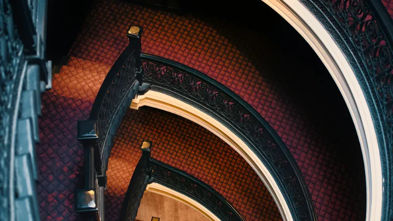Patterned red carpet on a curving staircase