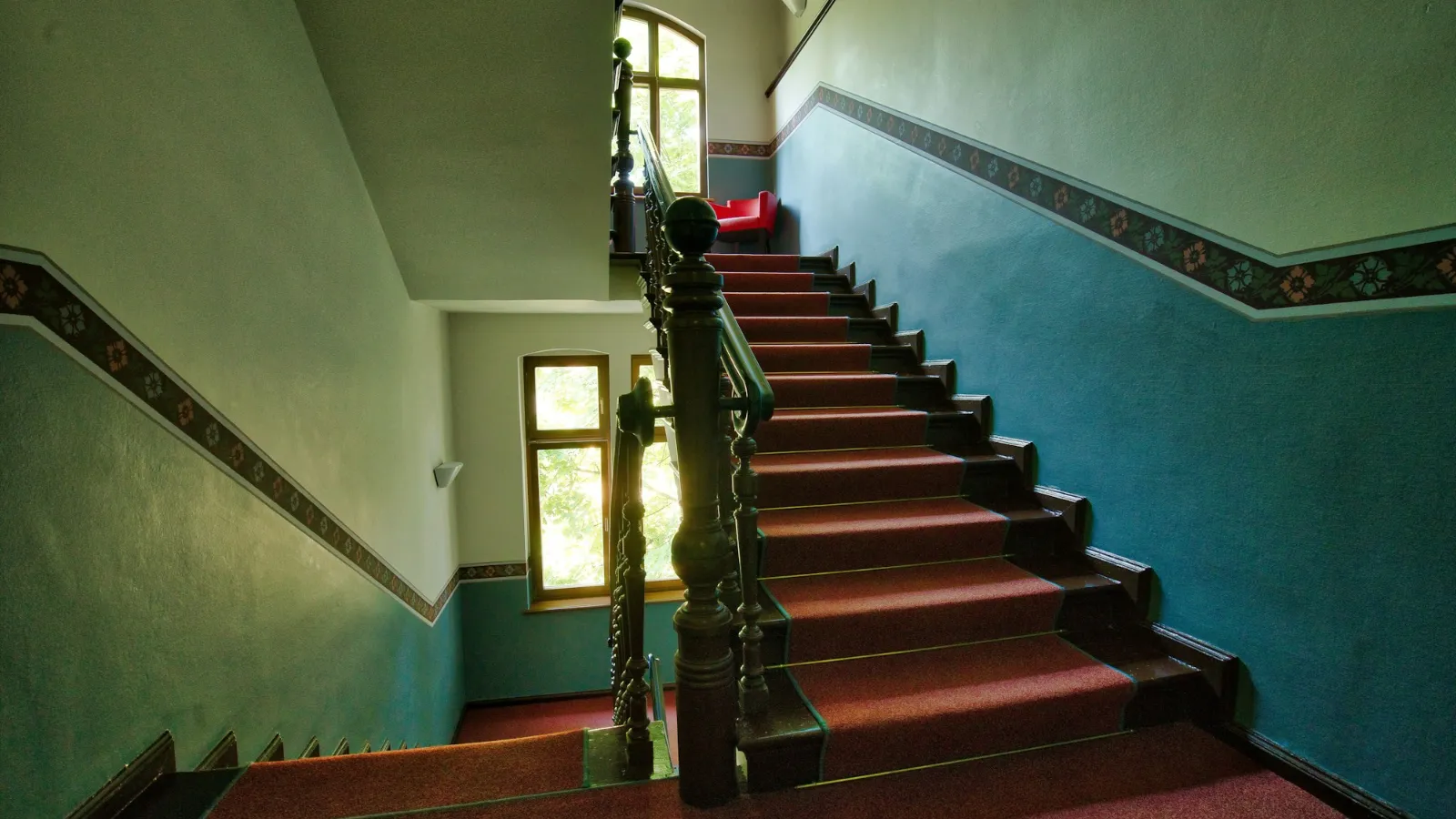 Red runner on a hallway staircase with painted walls
