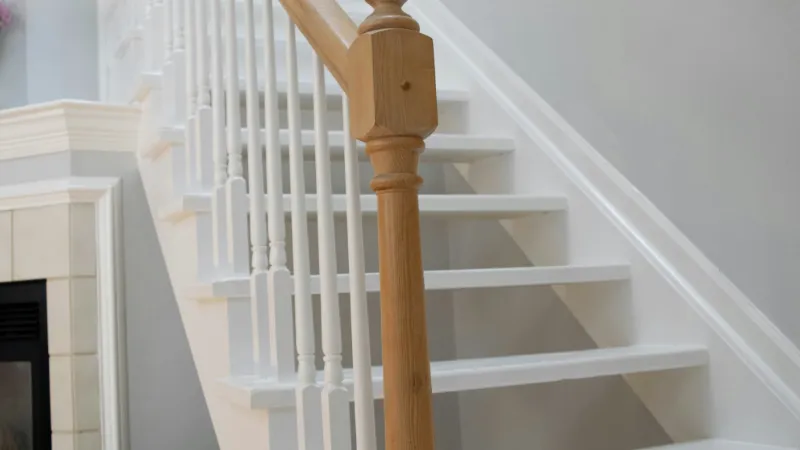 White staircase with a timber newel post and handrail